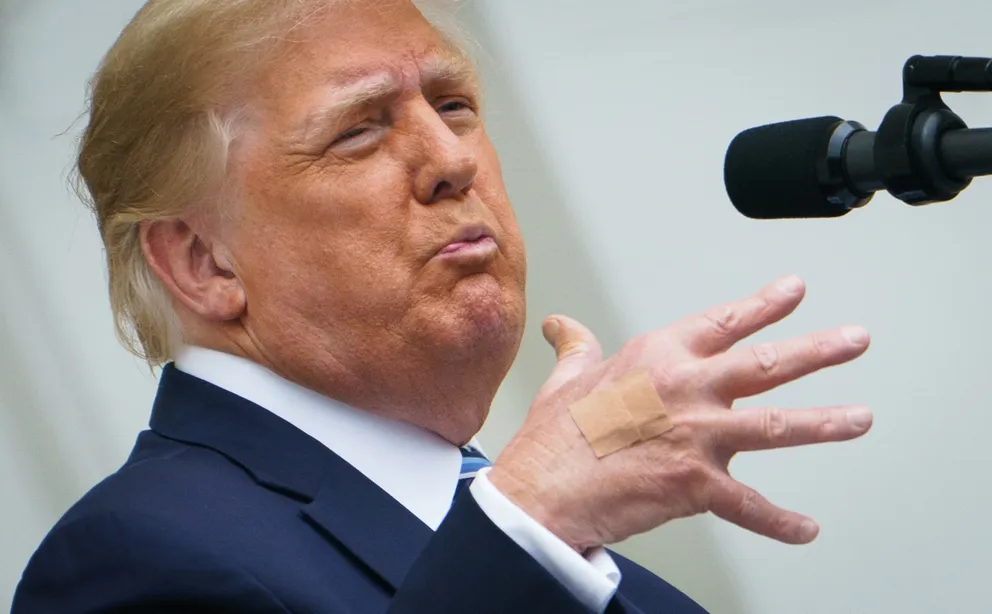 Bandages are seen on the back of his hand as Donald Trump speaks from the South Portico of the White House in Washington, DC during a rally on October 10, 2020 | Source: Getty Images